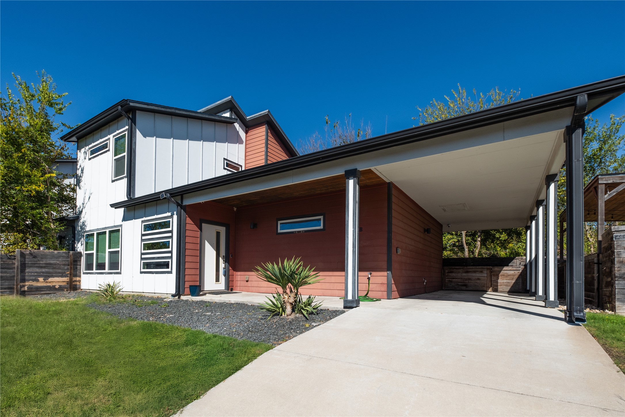 7601 Bethune Avenue, Unit B Austin, TX 78752 - Photo 1 of 39 Contemporary house featuring board and batten siding, driveway, a carport, and covered porch