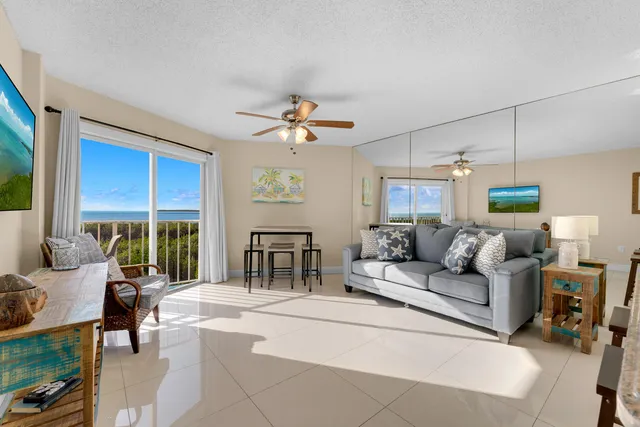 a living room with furniture a chandelier and a window