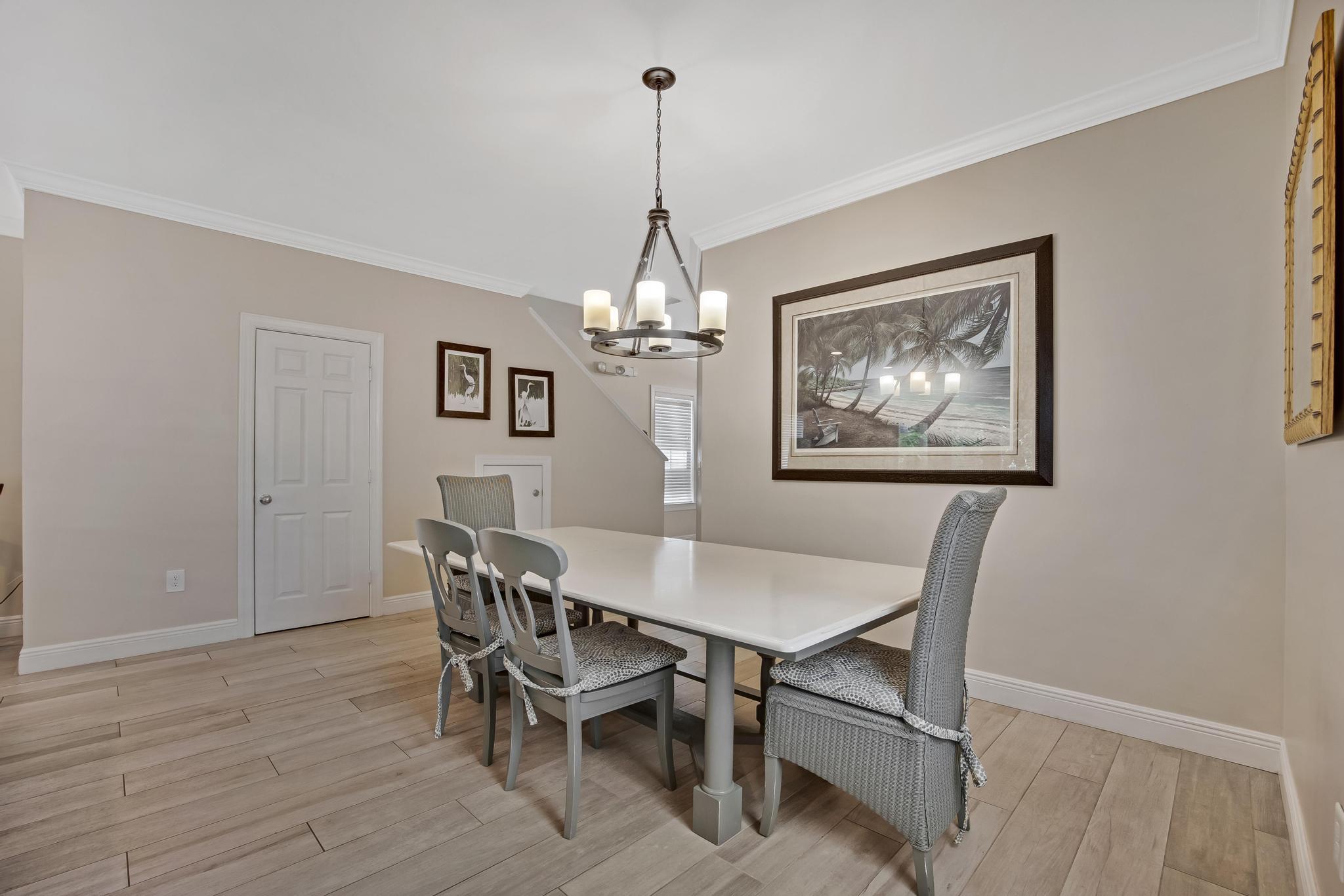 7204 Simran Lane Marathon, FL 33050 - Photo 9 of 47 a dining room with furniture a chandelier and wooden floor