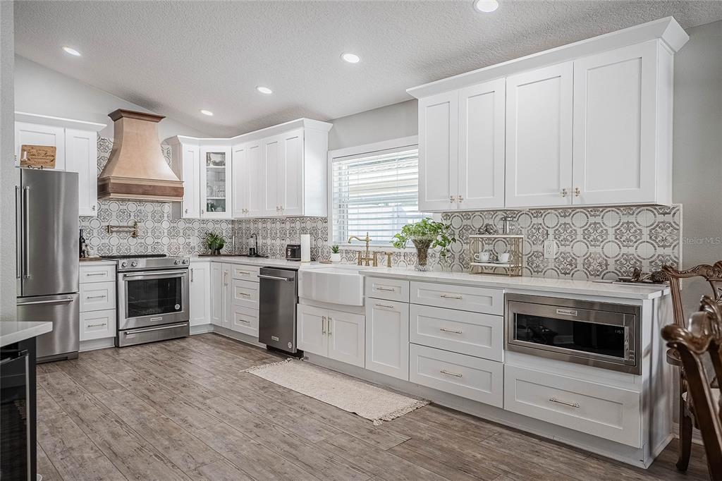 2524 Siena Way Valrico, FL 33596 - Photo 12 of 38 a kitchen with white cabinets stainless steel appliances and sink