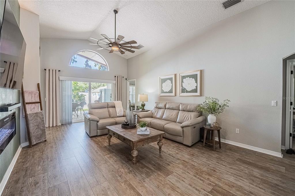 2524 Siena Way Valrico, FL 33596 - Photo 8 of 38 a living room with furniture a chandelier and a wooden floor