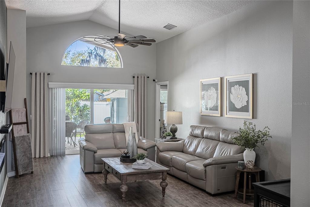 2524 Siena Way Valrico, FL 33596 - Photo 10 of 38 a living room with furniture a chandelier and a large mirror