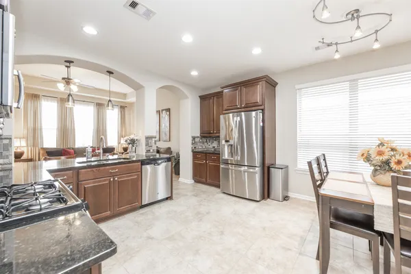 a kitchen with refrigerator and chairs