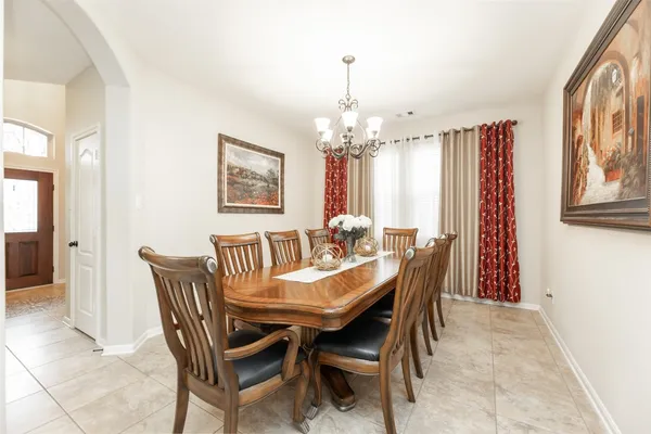 a dining room with furniture a chandelier and wooden floor