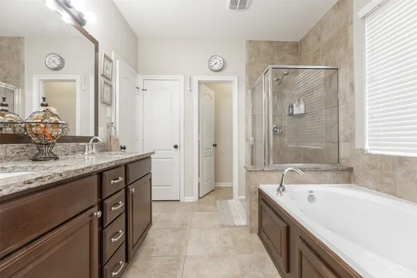 a spacious bathroom with a granite countertop tub sink shower and mirror
