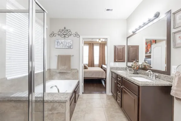 a en suite bathroom with a granite countertop sink mirror and bathtub