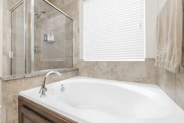 a white bath tub sitting in a bathroom next to a sink