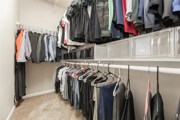a view of walk in closet with clothes and shoes