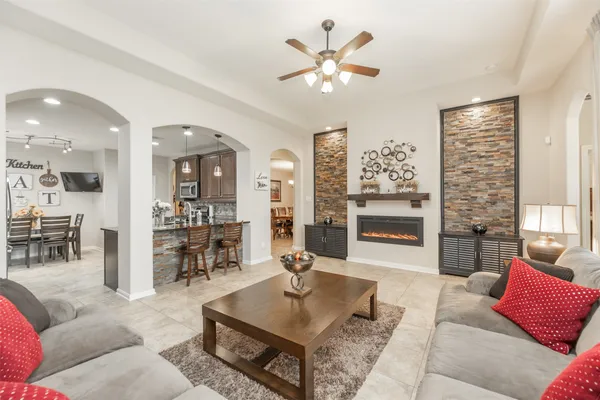 a living room with furniture kitchen view and a large window