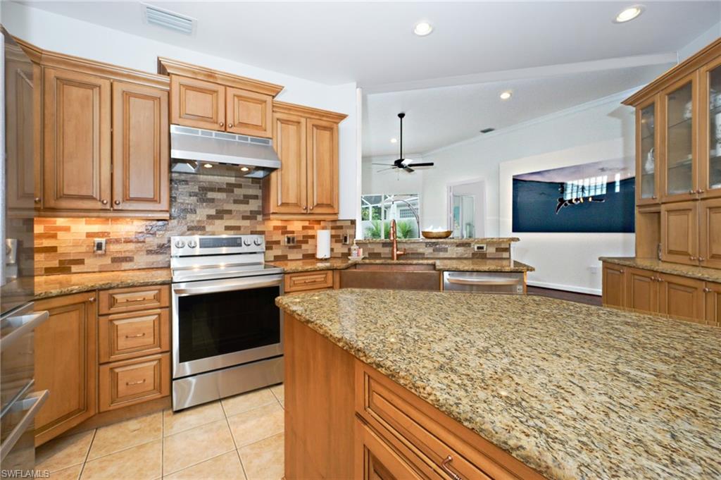 3188 Sundance Circle Naples, FL 34109 - Photo 17 of 39 a kitchen with stainless steel appliances granite countertop a stove a sink and a microwave
