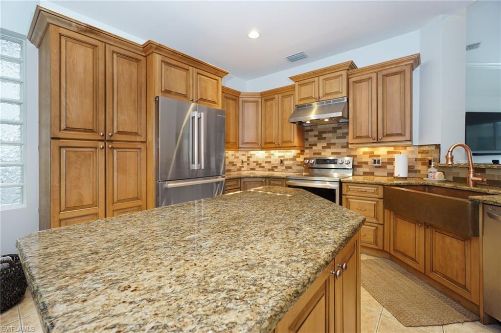 3188 Sundance Circle Naples, FL 34109 - Photo 18 of 39 a kitchen with kitchen island sink stove and refrigerator