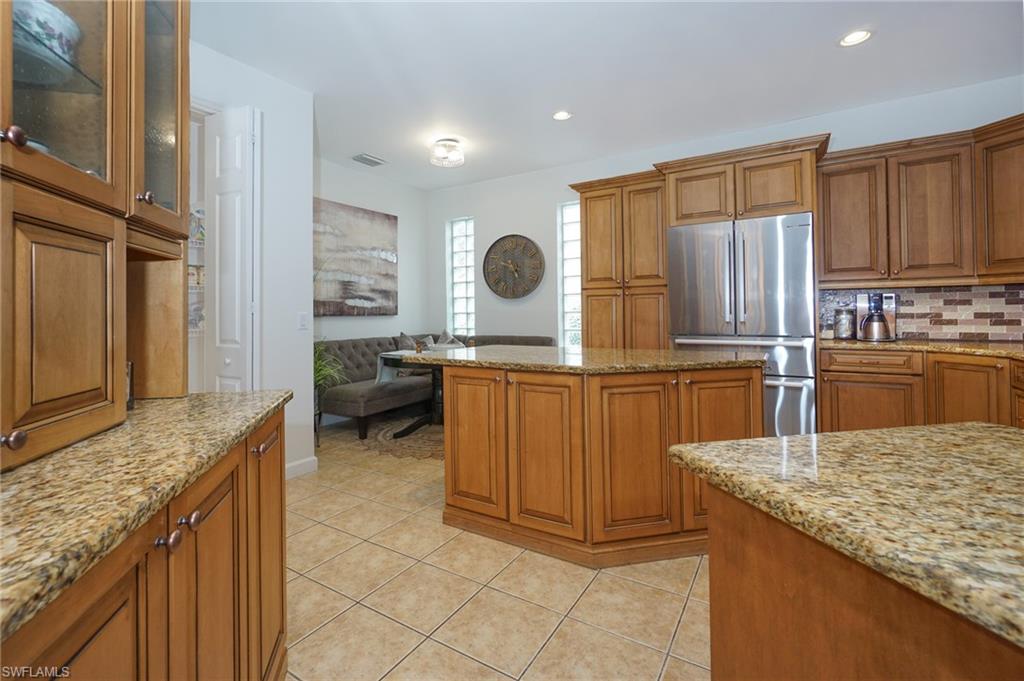 3188 Sundance Circle Naples, FL 34109 - Photo 19 of 39 a kitchen with granite countertop a sink stove and cabinets