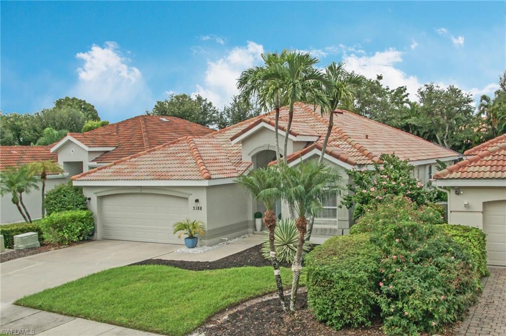 3188 Sundance Circle Naples, FL 34109 - Photo 2 of 39 a front view of a house with a garden and plants