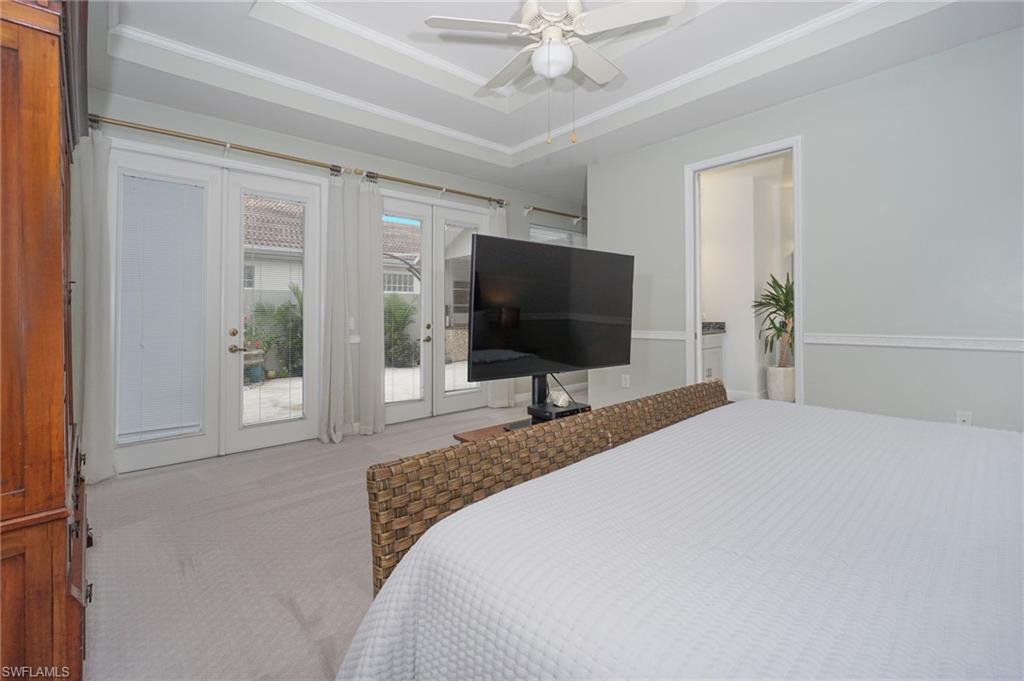 3188 Sundance Circle Naples, FL 34109 - Photo 23 of 39 a bedroom with a bed and a flat screen tv