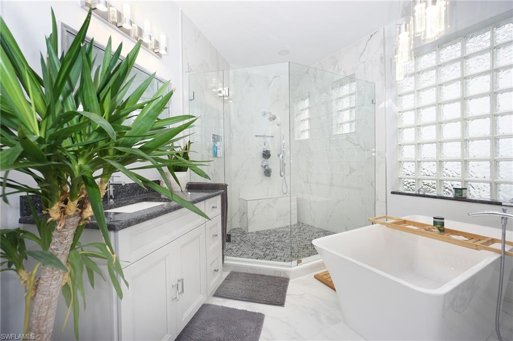 3188 Sundance Circle Naples, FL 34109 - Photo 25 of 39 a bathroom with a sink a mirror and a bathtub