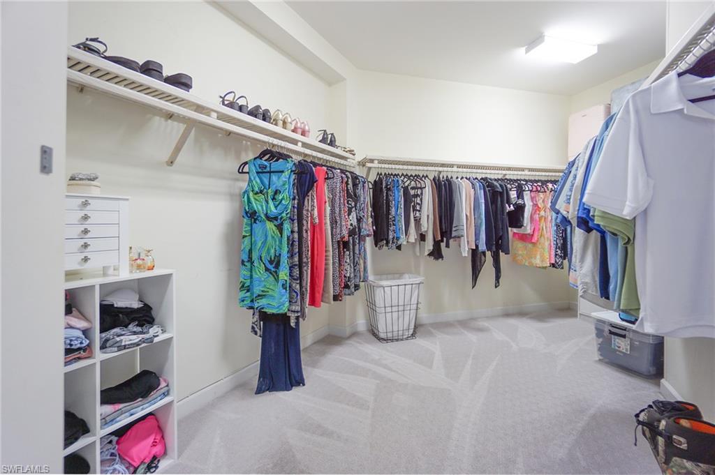 3188 Sundance Circle Naples, FL 34109 - Photo 26 of 39 a view of walk in closet with clothes and shoes