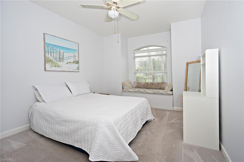 3188 Sundance Circle Naples, FL 34109 - Photo 27 of 39 a bedroom with a large bed and a chandelier