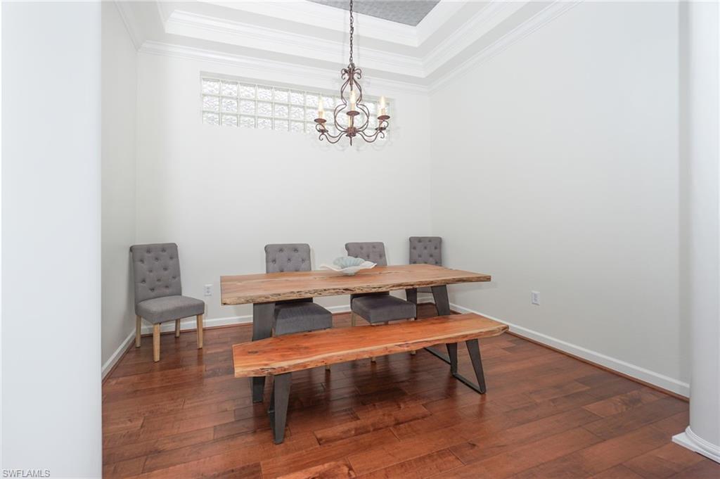 3188 Sundance Circle Naples, FL 34109 - Photo 7 of 39 a view of a dining room with furniture and wooden floor