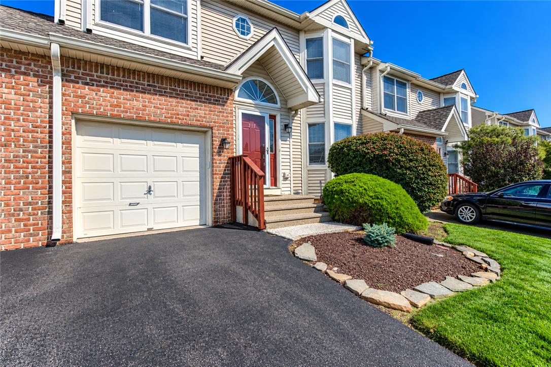 Brick accents and vinyl siding define this multi-level exterior complete with an attached garage.