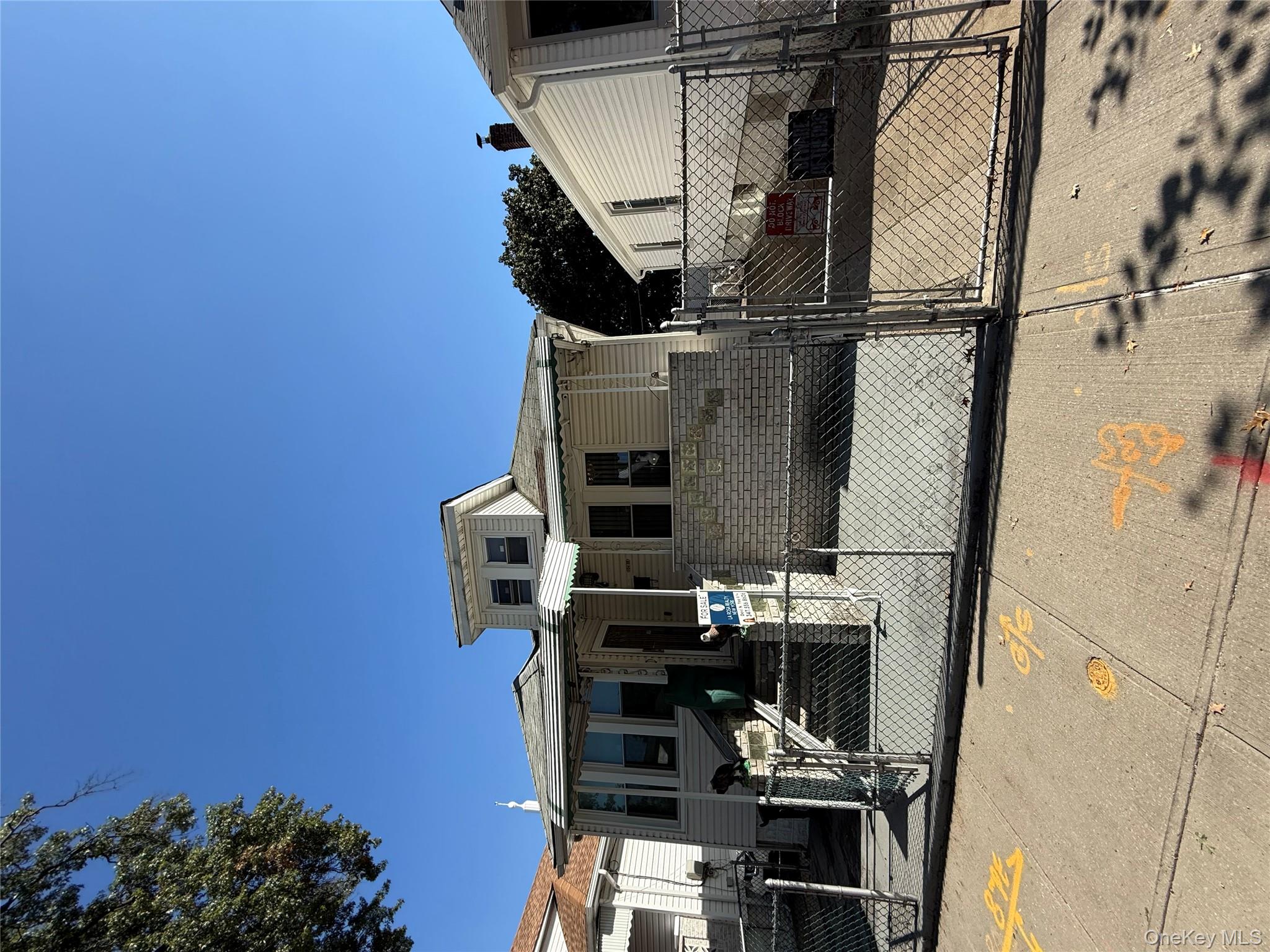 View of front of home with a gate, a fenced front yard, and brick siding