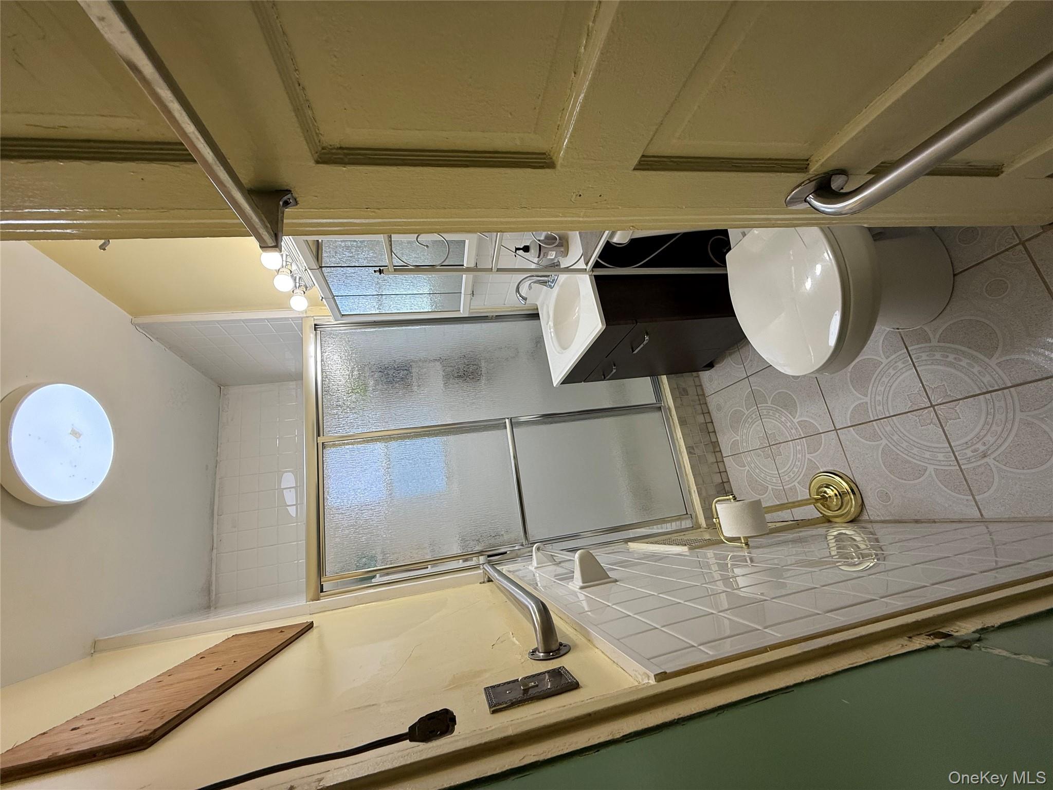 104-25 126th Street Queens, NY 11419 - Photo 4 of 22 Bathroom featuring light tile patterned floors, vanity, and a shower stall