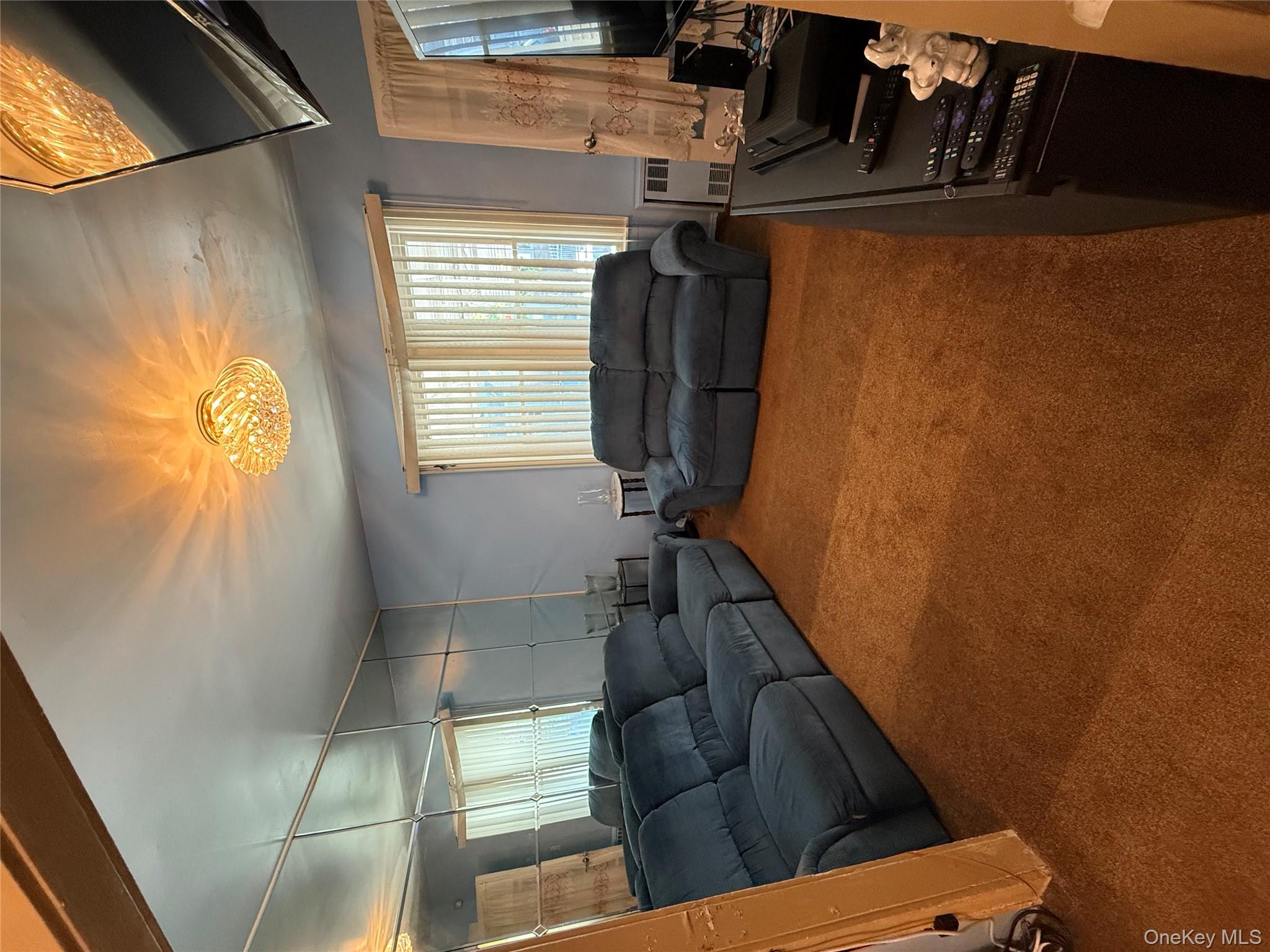 104-25 126th Street Queens, NY 11419 - Photo 7 of 22 Living room with carpet and radiator heating unit