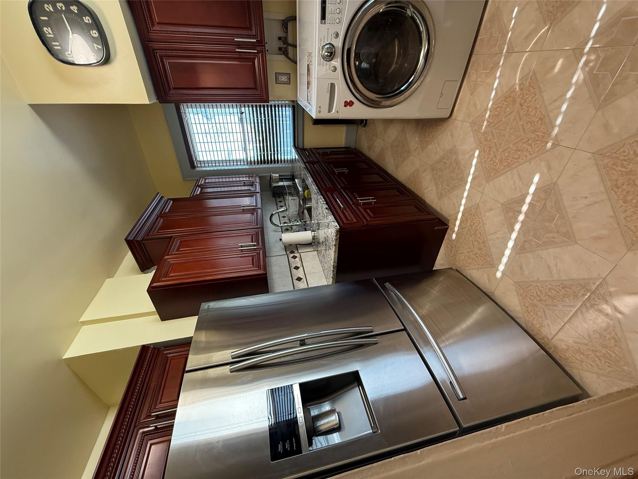 104-25 126th Street Queens, NY 11419 - Photo 9 of 22 Laundry room with washer / dryer and light tile patterned flooring