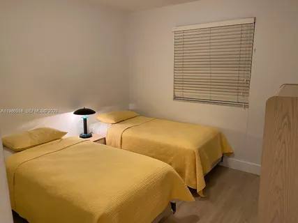 a bedroom with two beds and a window