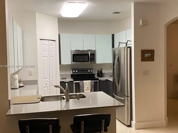 a kitchen with a sink microwave and refrigerator