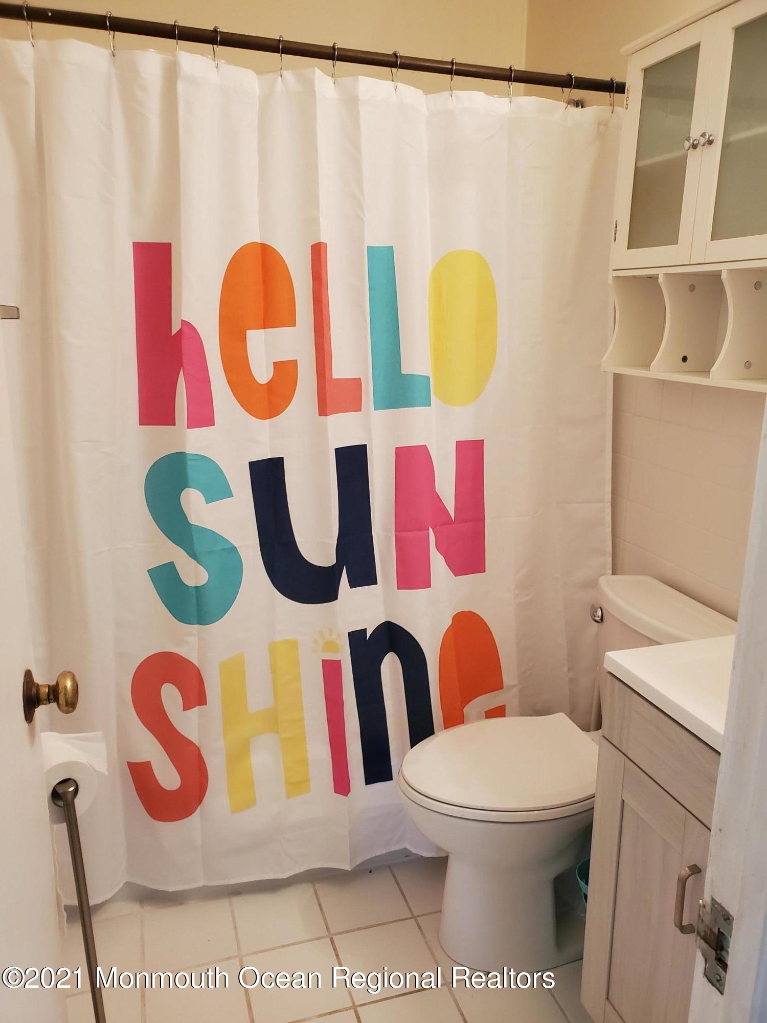 5 Calvert Avenue, Unit B Long Branch, NJ 07740 - Photo 5 of 12 a bathroom with a toilet and a shower curtain