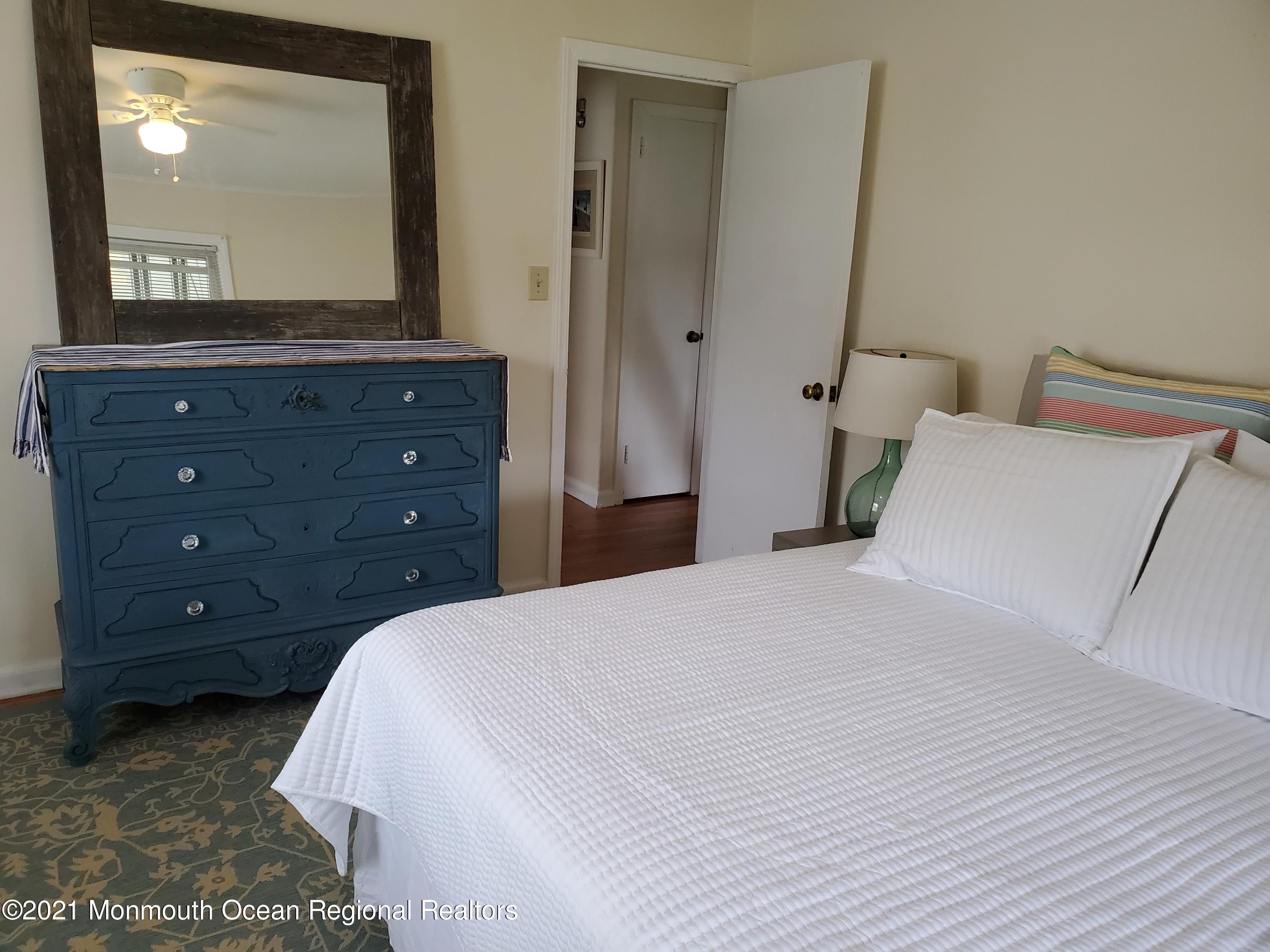 5 Calvert Avenue, Unit B Long Branch, NJ 07740 - Photo 10 of 12 a bedroom with a bed and a mirror on dresser