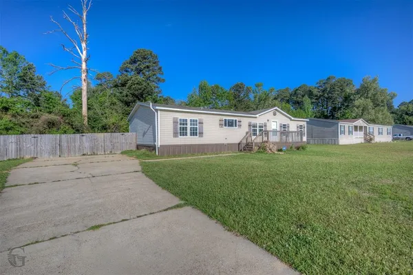 a view of house with backyard and garden