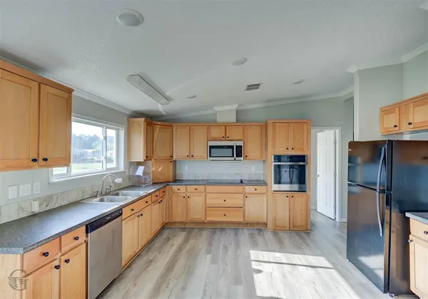 a large kitchen with cabinets a sink and appliances