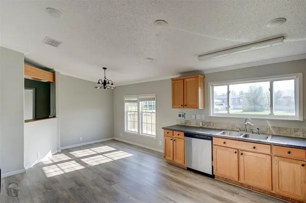 a kitchen with granite countertop a sink stove and cabinets