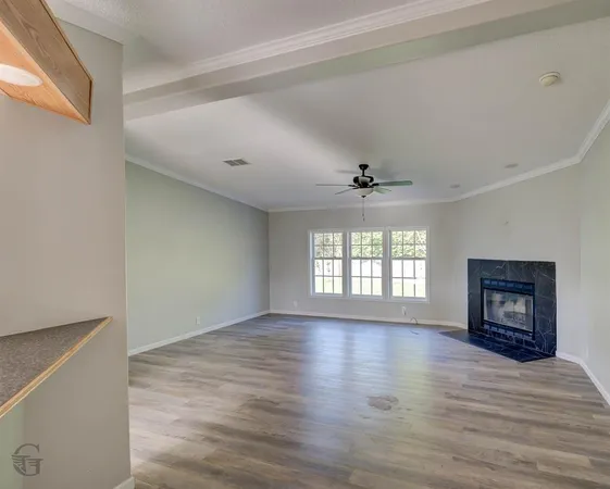a view of an empty room with a window and a fireplace
