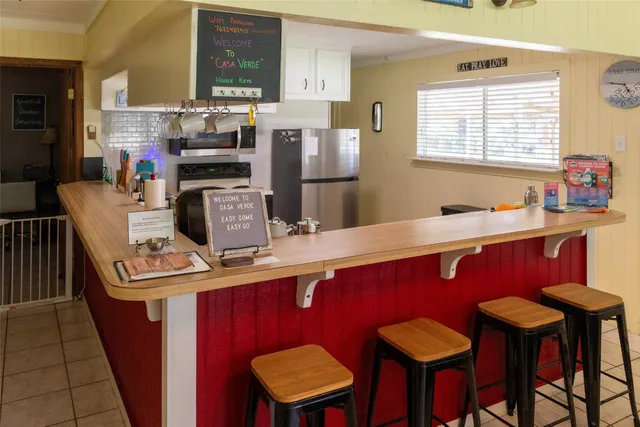 a kitchen with stainless steel appliances kitchen island granite countertop a dining table chairs and sink