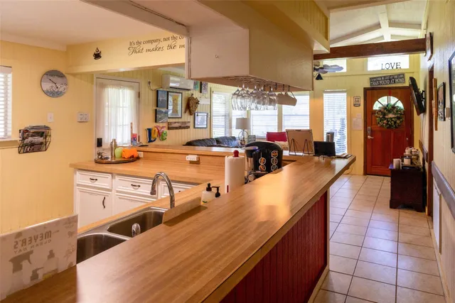 a dining hall with stainless steel appliances kitchen island granite countertop a sink and cabinets