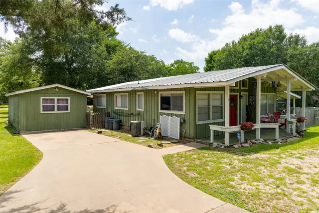 a patio with a table and chairs and potted plants