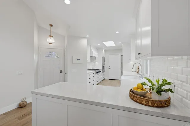 a kitchen with white cabinets and a window