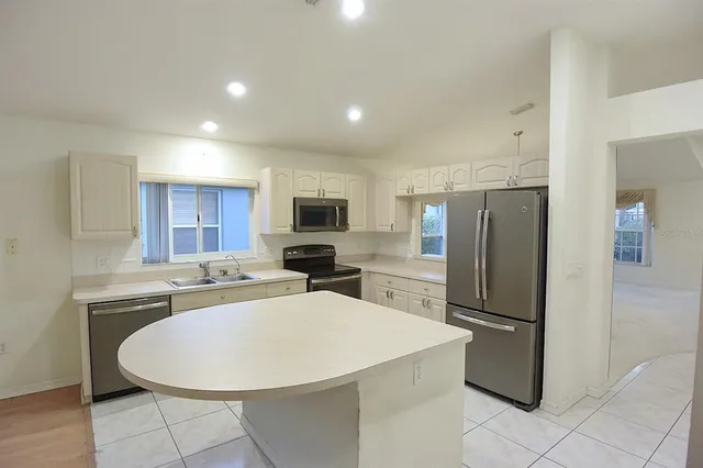 a kitchen with a refrigerator and a stove top oven
