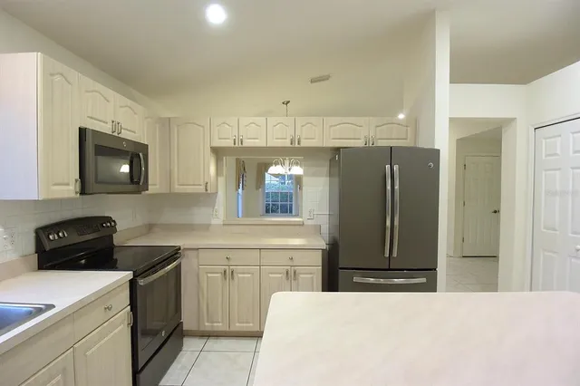 a kitchen with granite countertop white cabinets and stainless steel appliances