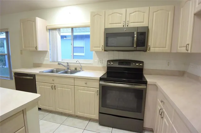 a kitchen with stainless steel appliances a stove sink microwave and cabinets