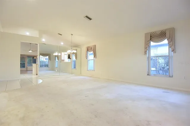 a view of empty room with window and ceiling fan