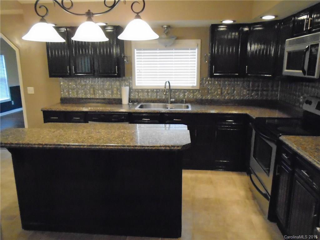 1260 Wayfield Road, Unit 3 Clover, SC 29710 - Photo 4 of 24 a kitchen with granite countertop a sink a stove and cabinets