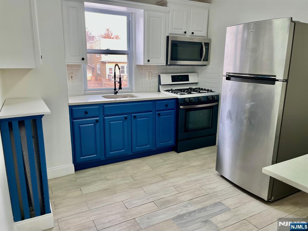 46 Webster Street, Unit 2 Ridgefield Park, NJ 07660 - Photo 4 of 10 a kitchen with stainless steel appliances a refrigerator stove and sink