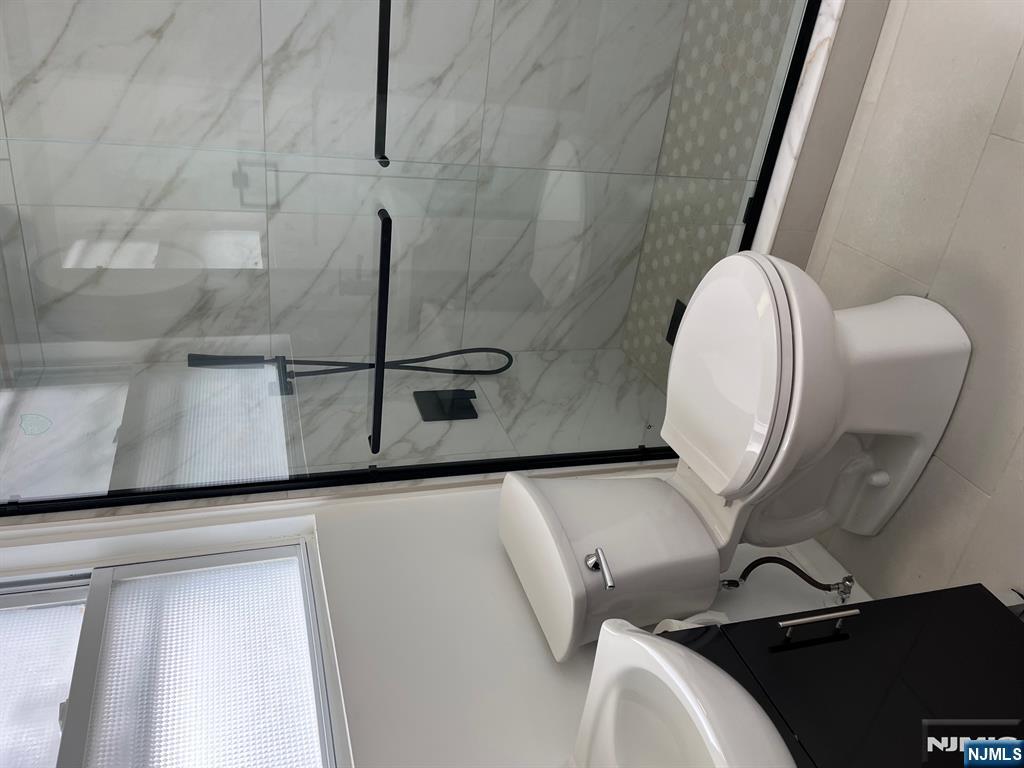 46 Webster Street, Unit 2 Ridgefield Park, NJ 07660 - Photo 8 of 10 a white toilet sitting next to a bathroom sink