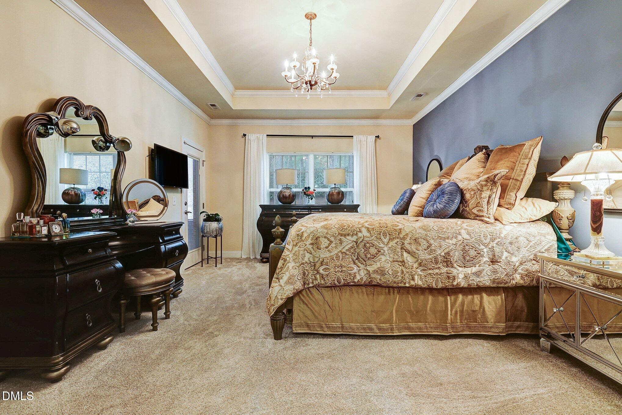 128 Dereham Lane Garner, NC 27529 - Photo 14 of 29 a bedroom with a bed and a chandelier