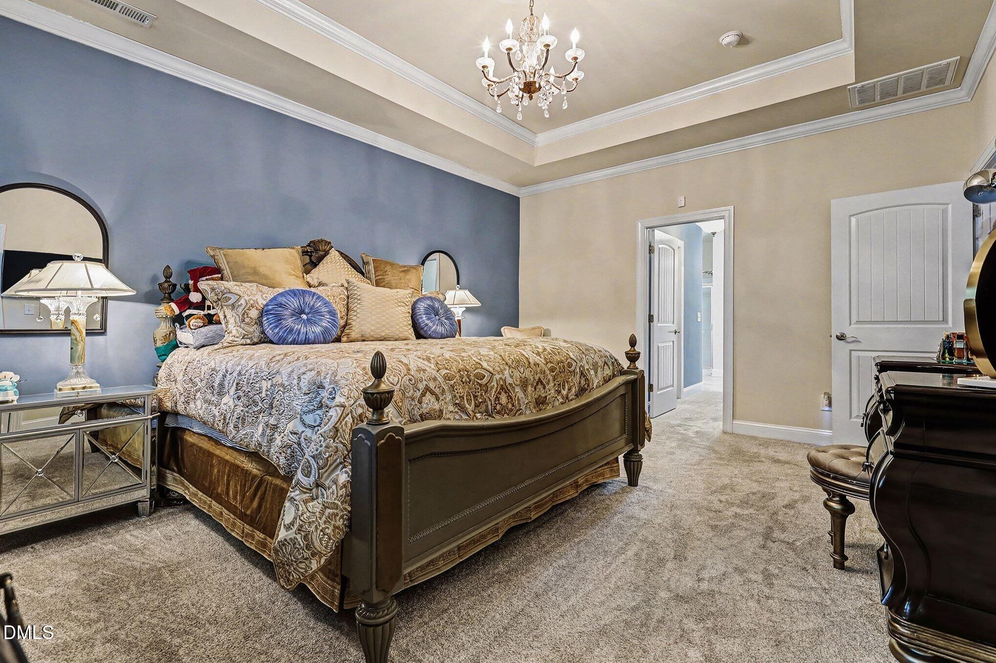 128 Dereham Lane Garner, NC 27529 - Photo 16 of 29 a bedroom with a bed and a chandelier