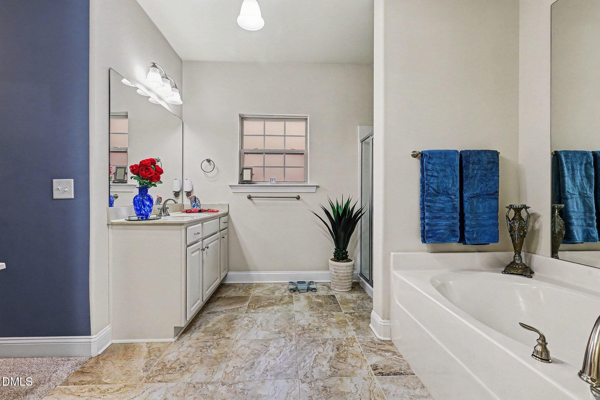 128 Dereham Lane Garner, NC 27529 - Photo 18 of 29 a bathroom with a tub sink and mirror
