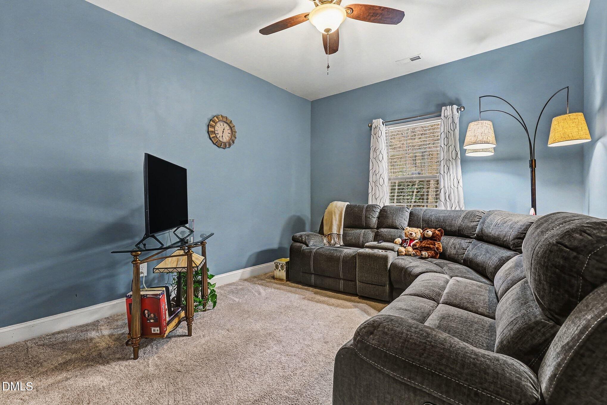 128 Dereham Lane Garner, NC 27529 - Photo 24 of 29 a living room with furniture and a flat screen tv